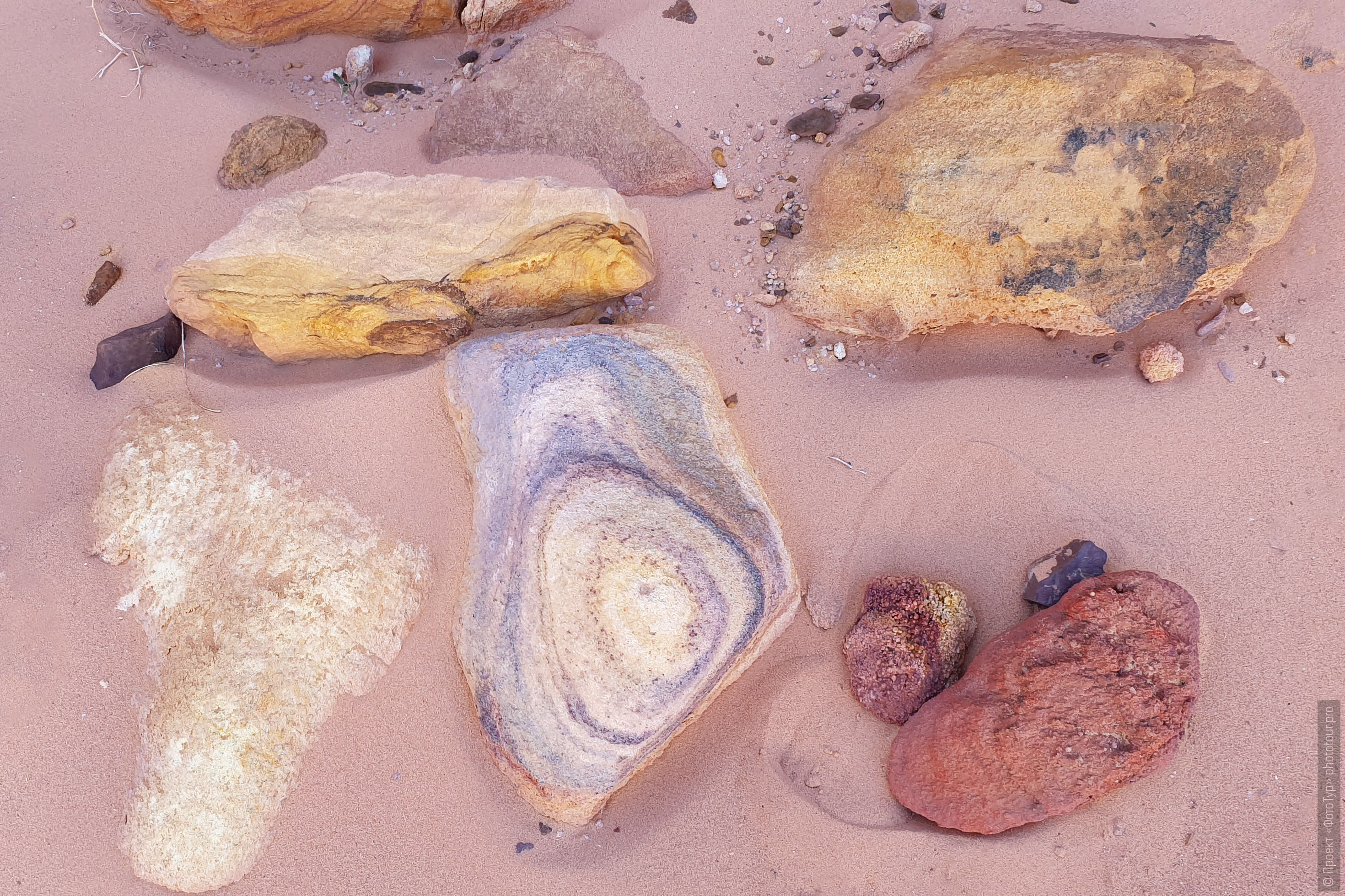 Натюрморт из разноцветных камней на розовом песке в пустыне Синая, Дахаб, Египет.