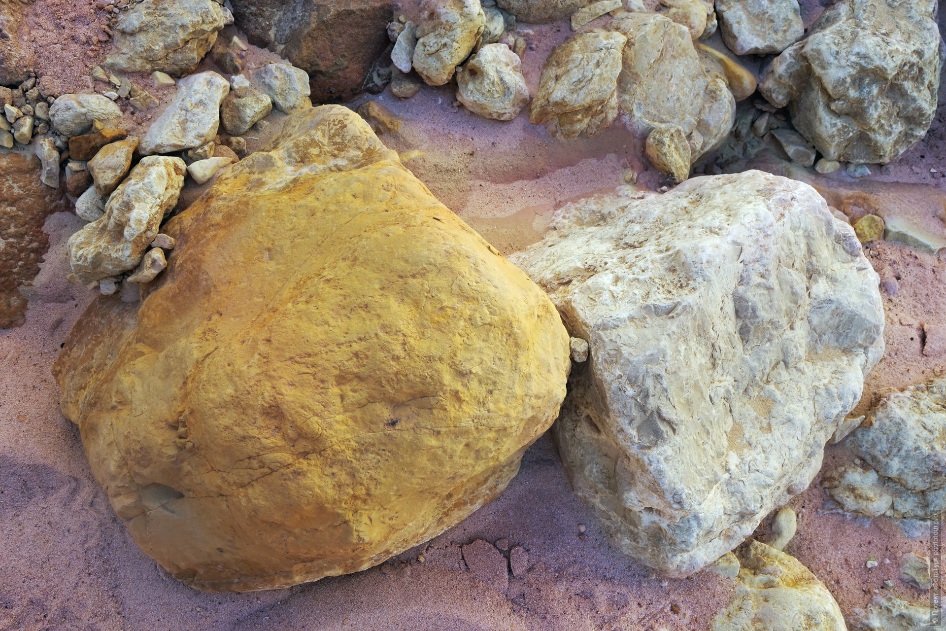 Желтый и белый камни на розовом песке в пустыне Синая, Дахаб, Египет.